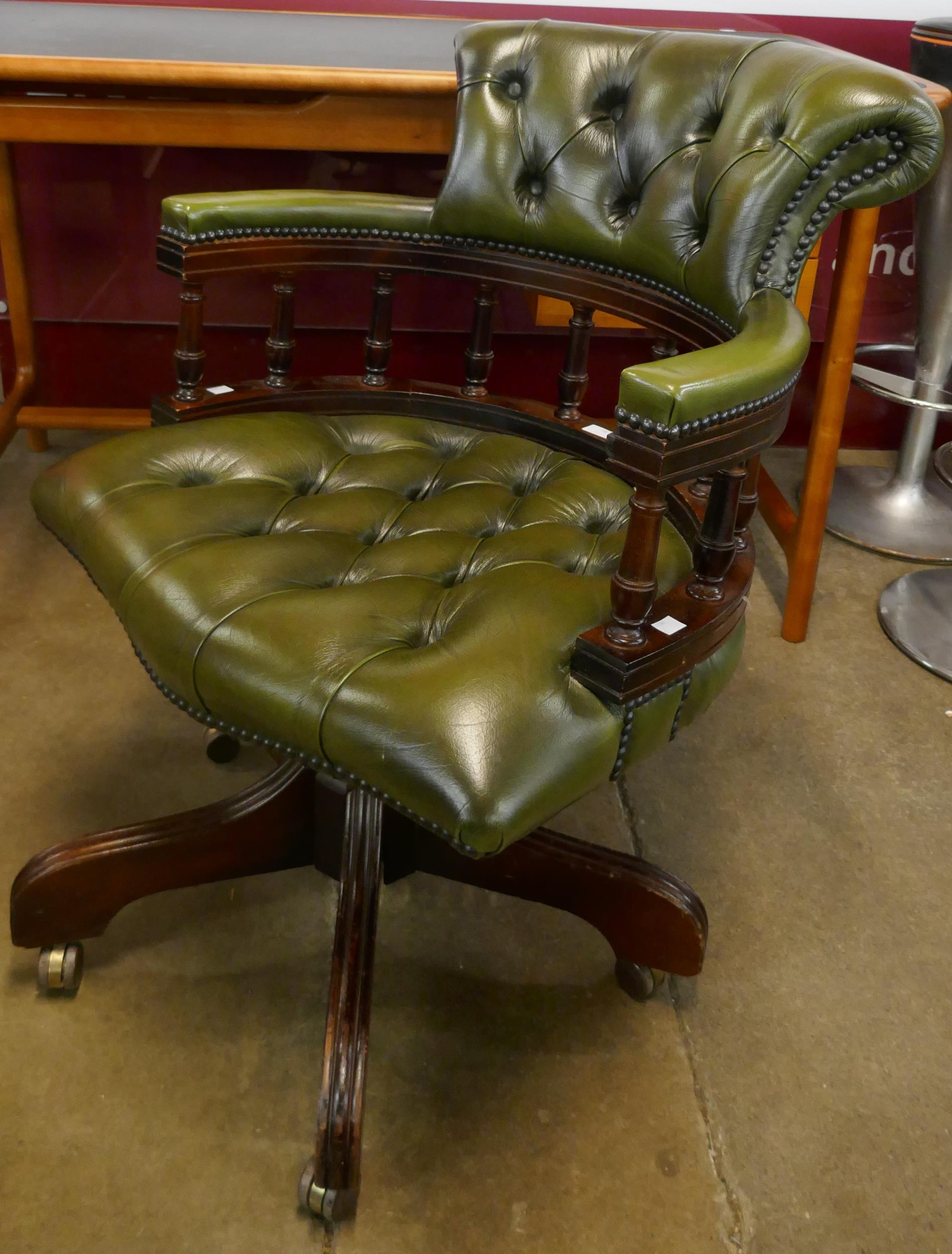 A mahogany and green leather revolving Captain's desk chair