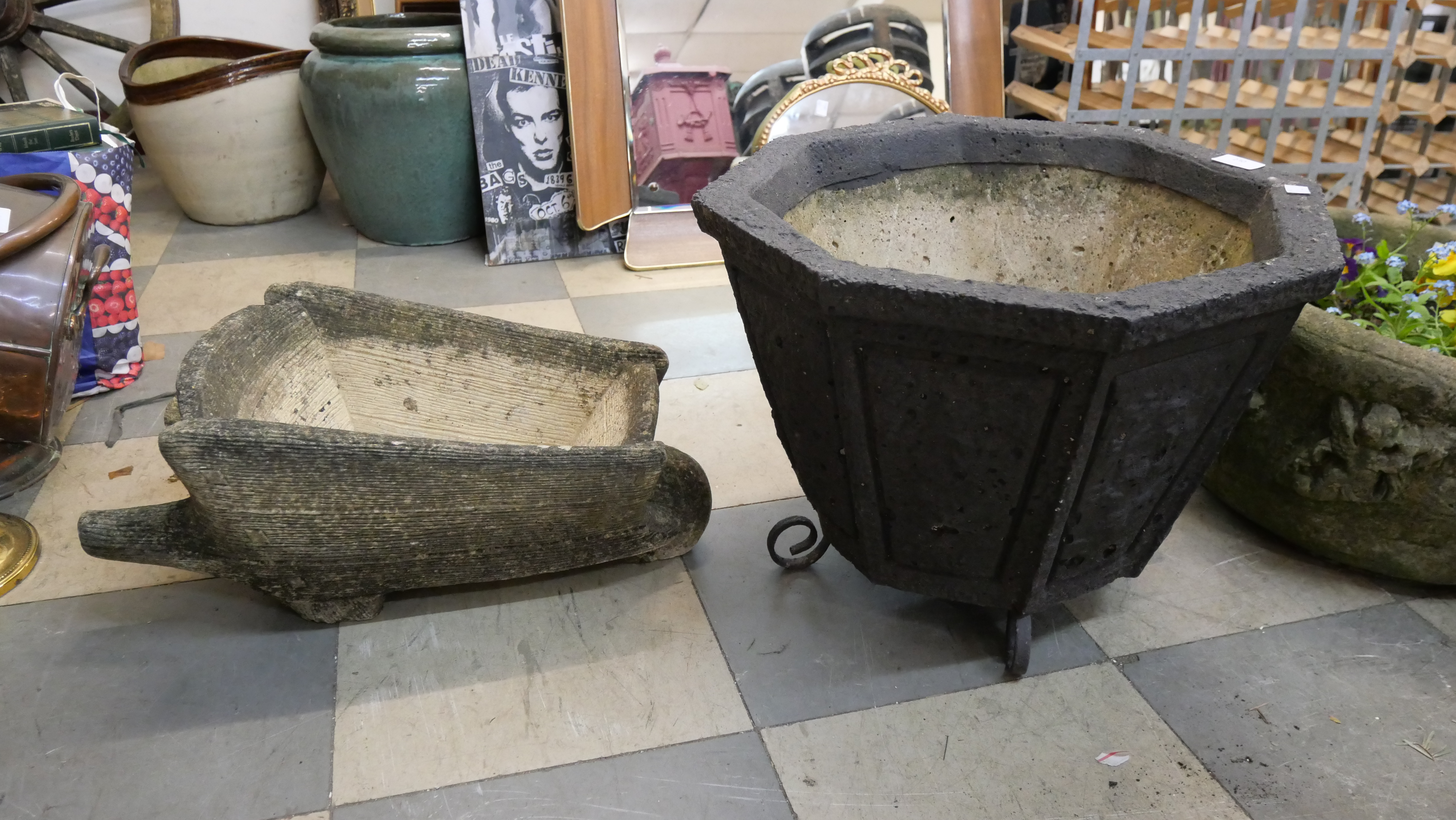 A concrete planter and a concrete wheelbarrow planter