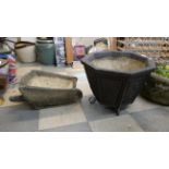 A concrete planter and a concrete wheelbarrow planter