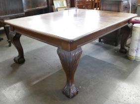 An early 20th Century Queen Anne style mahogany dining table with additional leaf and winding handle
