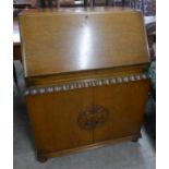 An early 20th Century carved oak bureau