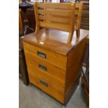 A teak chest of drawers and a magazine rack