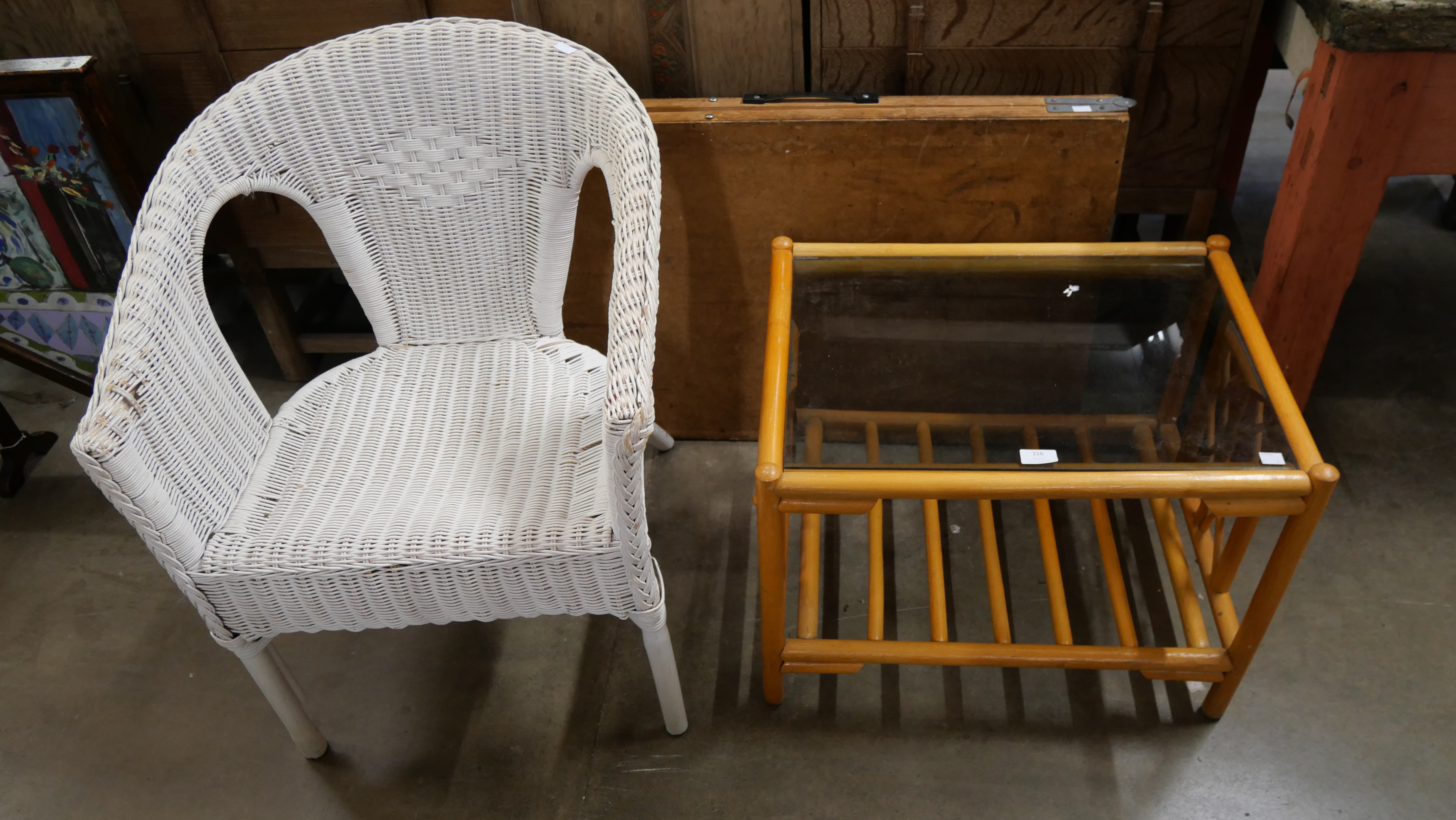 A bamboo glass topped coffee table, a wicker chair and a fold out trestle table