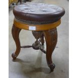 A Victorian carved walnut and leather topped stool