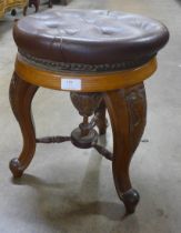 A Victorian carved walnut and leather topped stool