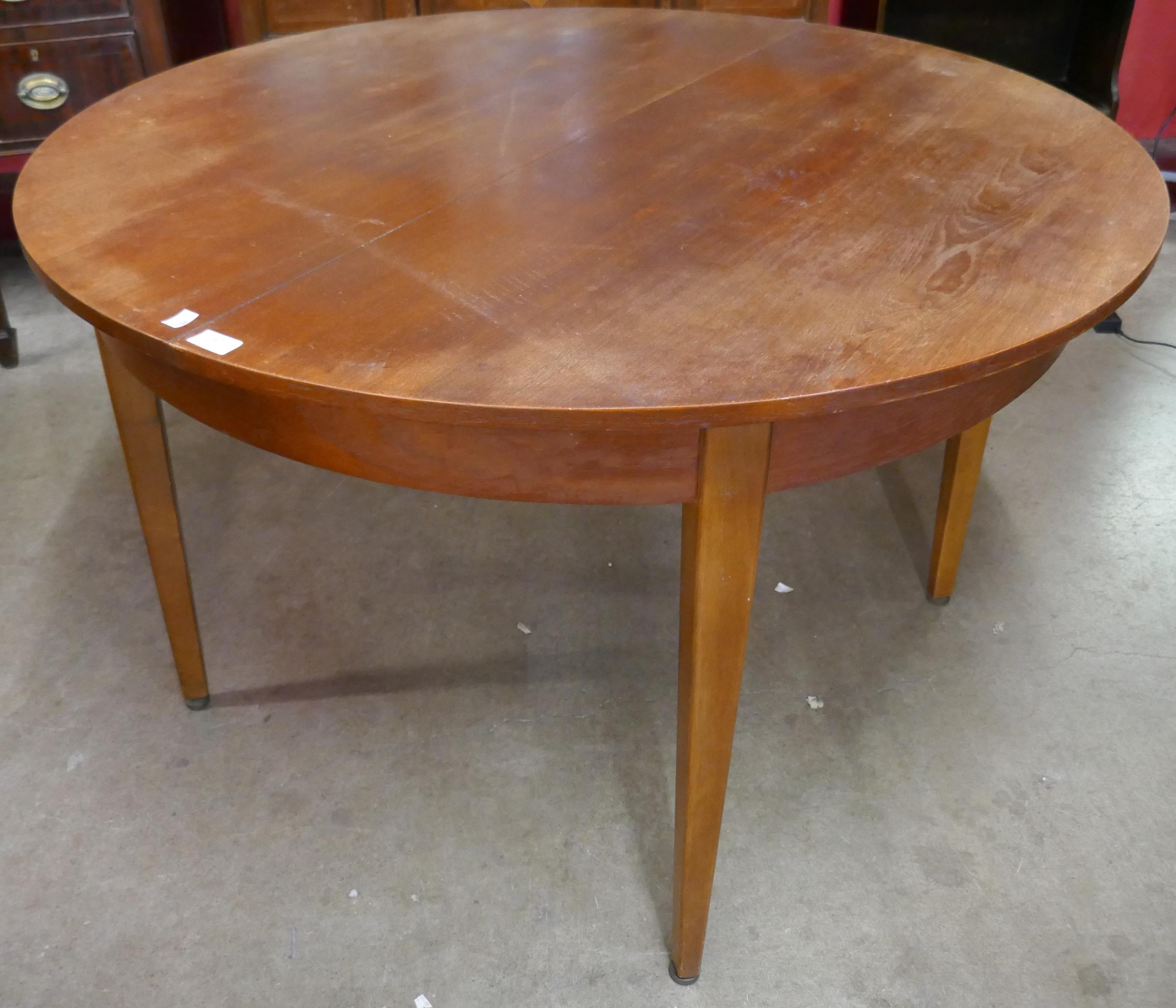 A teak extending circular dining table