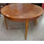 A teak extending circular dining table