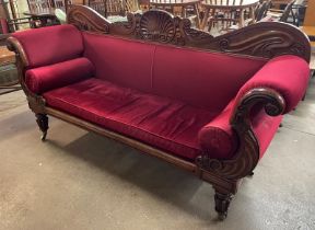 A Regency carved mahogany and red fabric upholstered scroll end settee