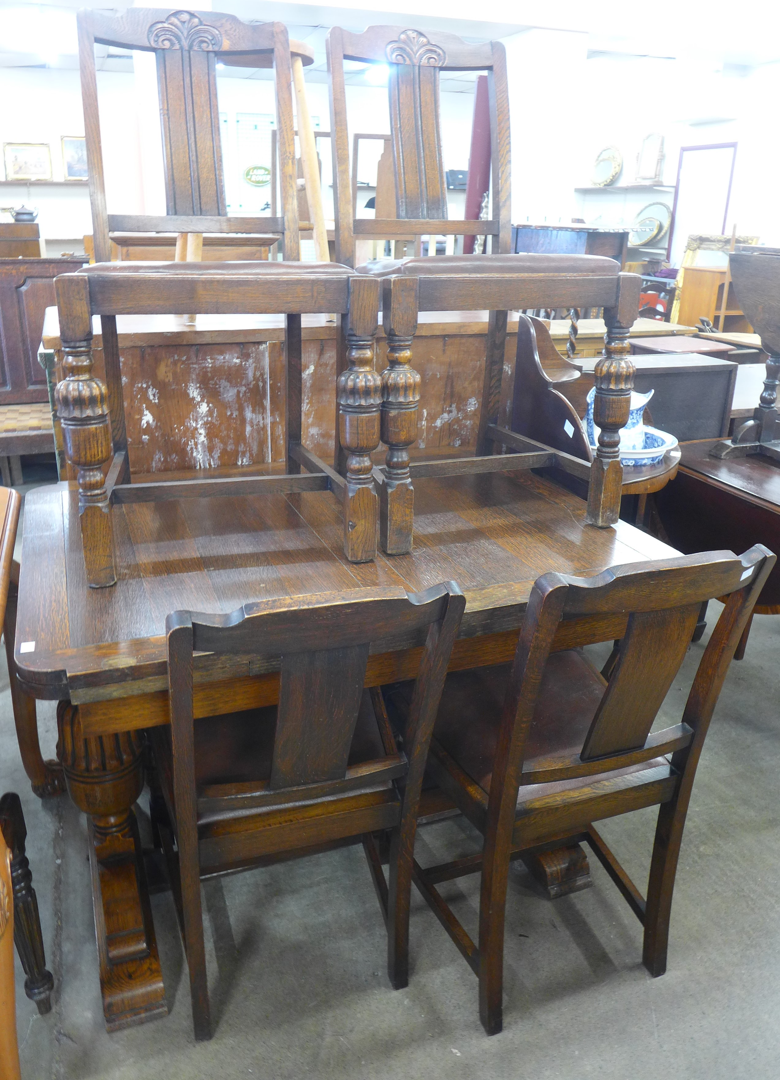 A carved oak draw leaf table and four chairs