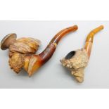 Two carved Meerschaum pipes, one with head of an African man and one of a Greek god