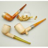 Four carved Meerschaum pipes, cased