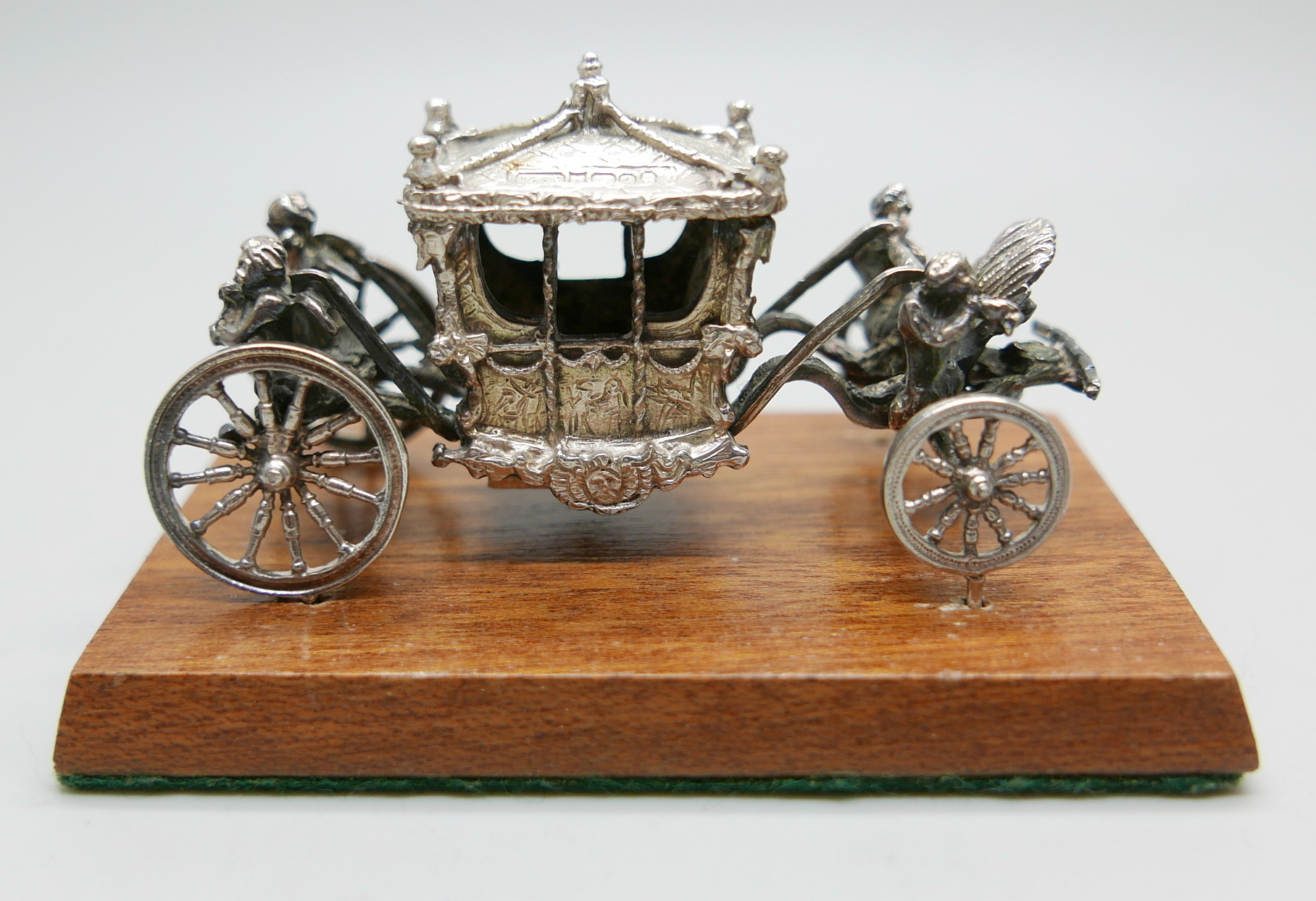 A hallmarked silver model Coronation coach, Birmingham 1977, Toye, Kenning & Spencer, wood base