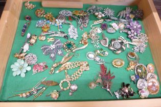 A collection of costume jewellery and brooches in a glass and wooden display case
