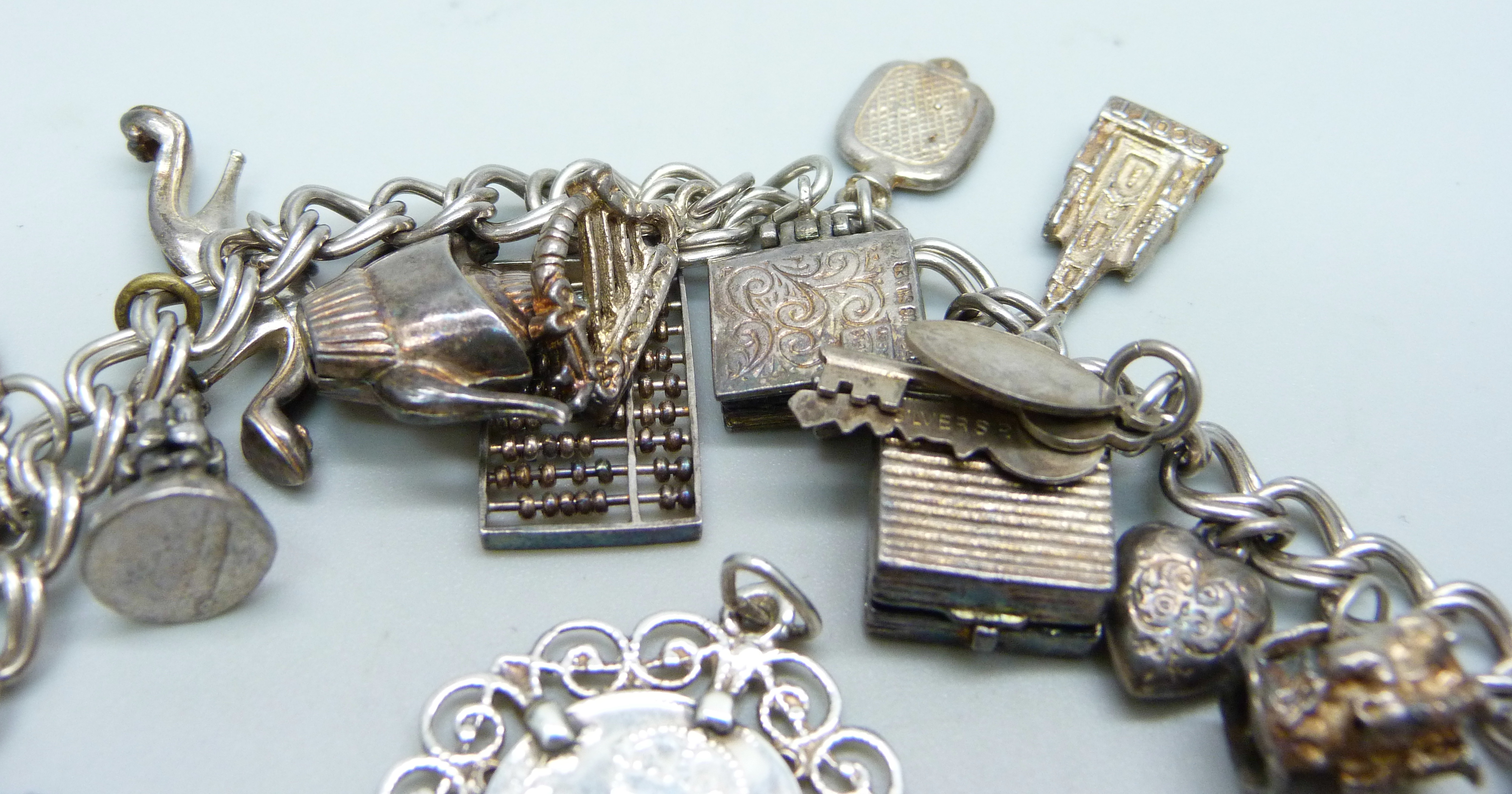 A silver charm bracelet, two silver pendants and a bracelet, 68g - Image 2 of 4
