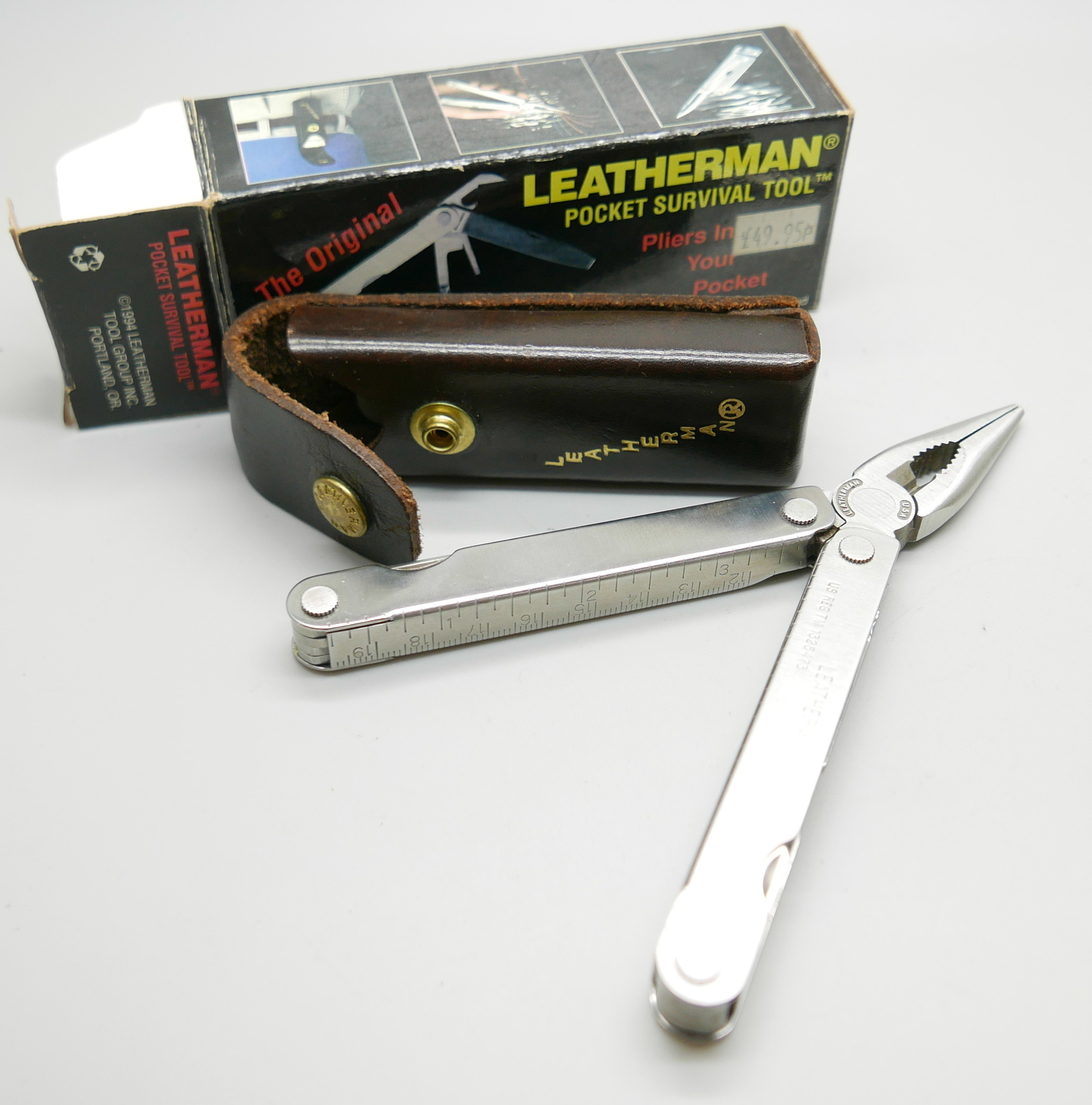 A Leatherman pocket survival tool, The Original, with leather case and outer box