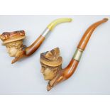 A carved Meerschaum pipe of a Victorian lady, amber stem, cased and one other loose