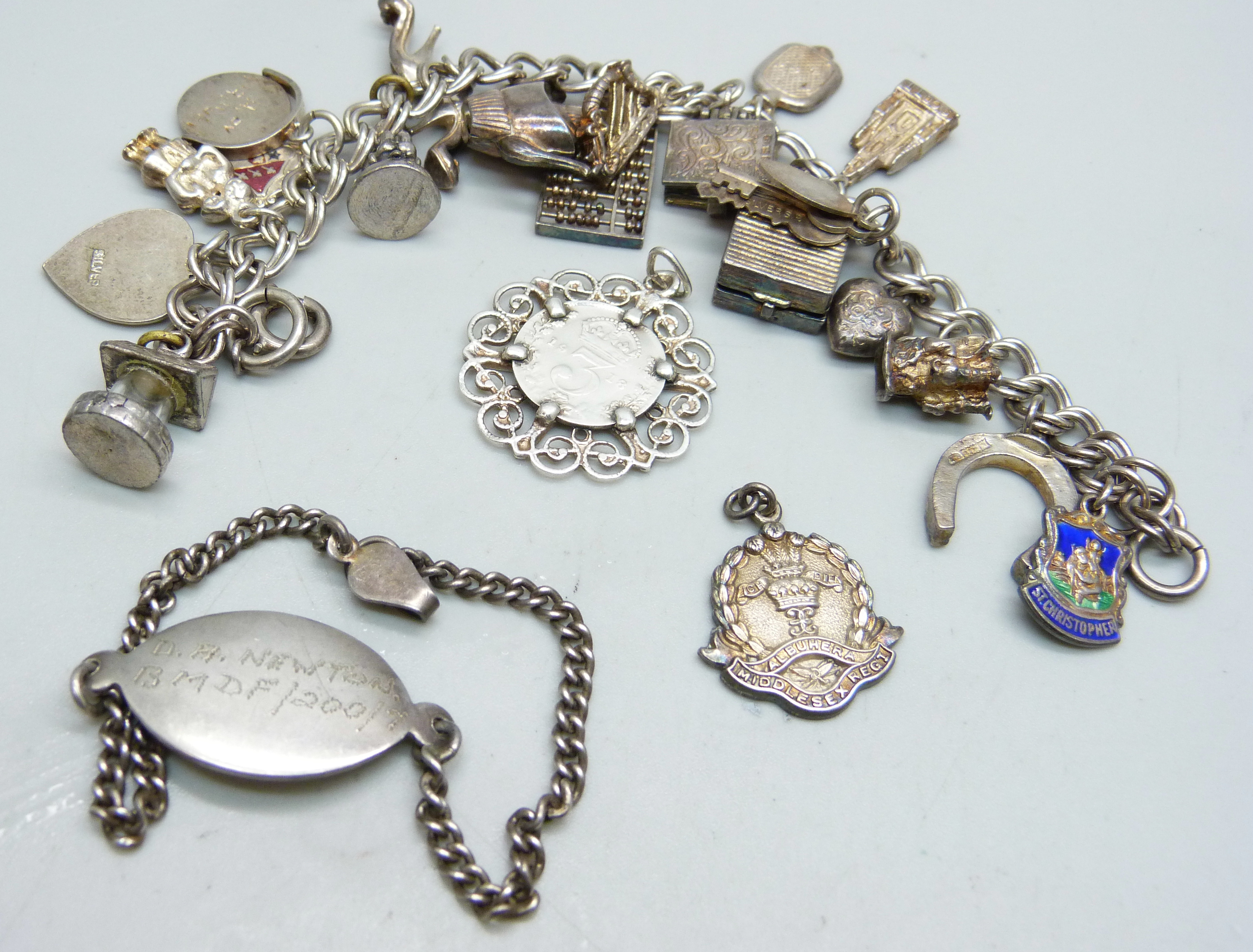 A silver charm bracelet, two silver pendants and a bracelet, 68g