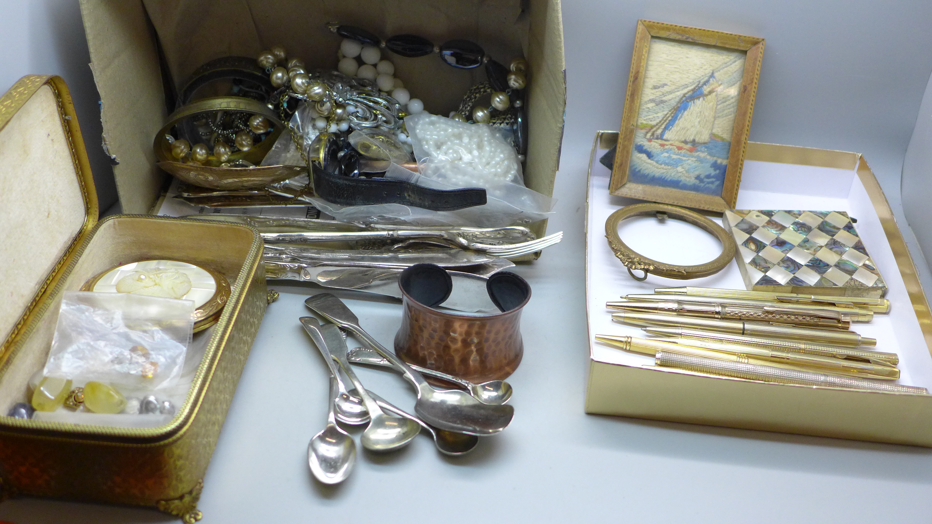 A gilt metal jewellery casket, costume jewellery, wristwatch, pens, spoons, fish knives and forks,