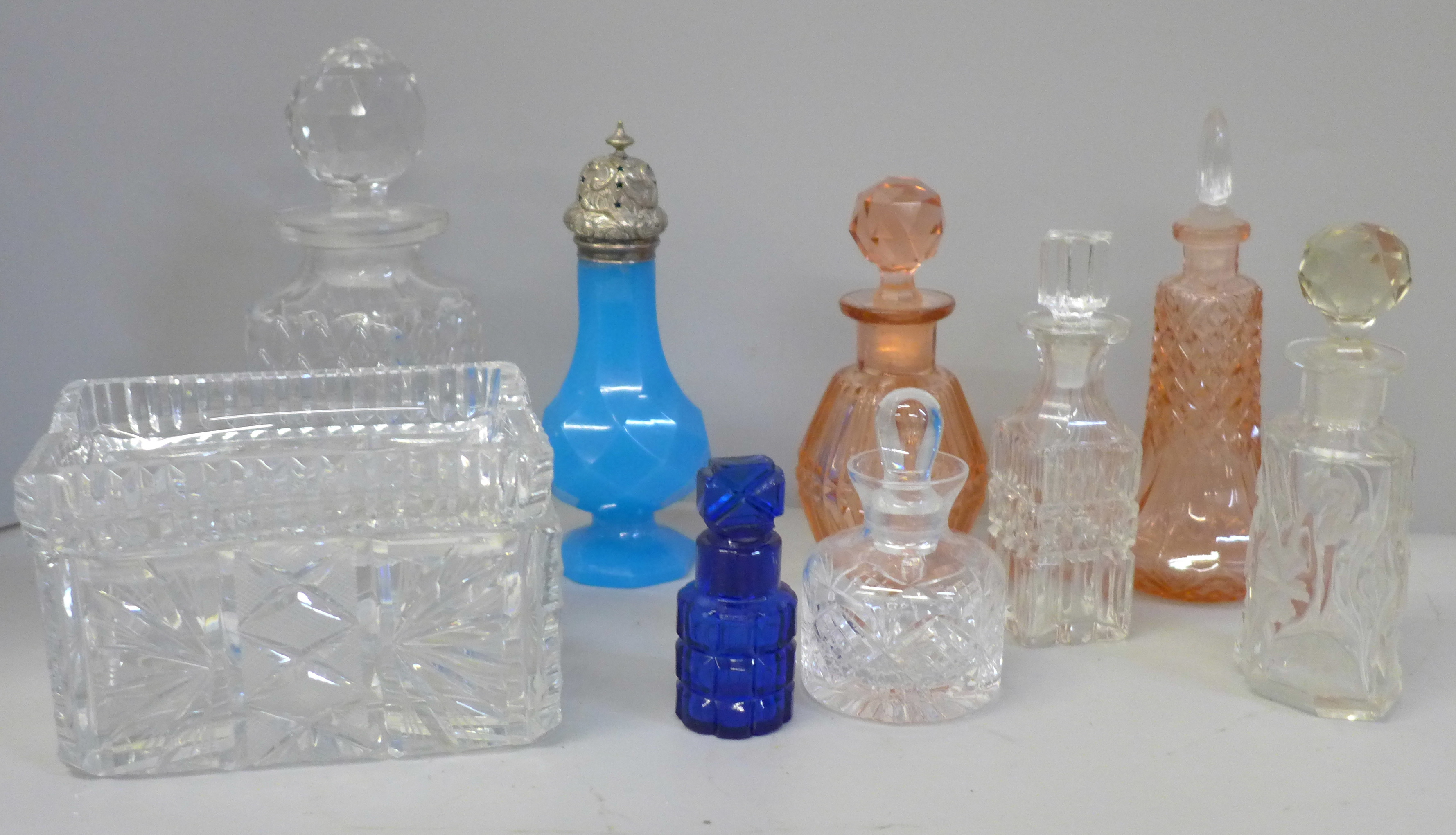 A collection of scent bottles and a glass cigarette box