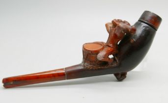 A 19th Century carved Meerschaum pipe depicting a monkey playing a drum, amber stem, cased