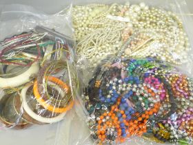 Three bags of costume jewellery including bangles, necklaces and faux pearls