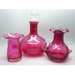 A cranberry glass decanter and two vases