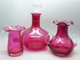A cranberry glass decanter and two vases
