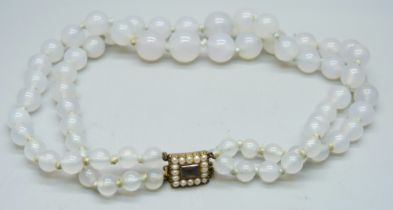 A selemite double string necklace on a c1900 yellow metal and pearl set clasp with hair memoriam