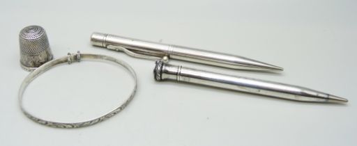 A hallmarked silver pencil, a plated Evesharp pencil, a silver bangle and a silver thimble