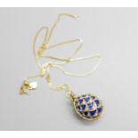 A Faberge style silver gilt and enamel egg pendant and chain