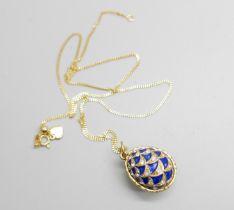 A Faberge style silver gilt and enamel egg pendant and chain