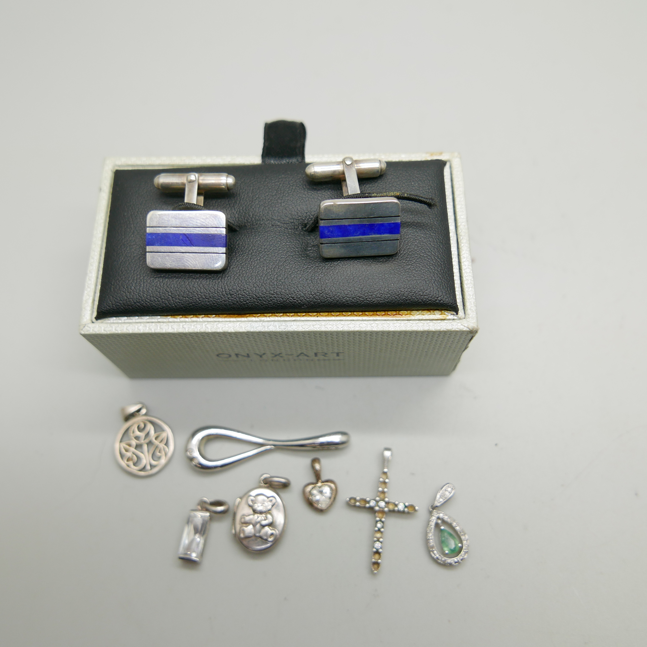A pair of silver cufflinks and seven silver pendants, (cross lacking stones)