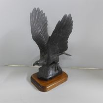 A Heredites Limited carved figure of an eagle by Tom Mackie, 97/500 on a wooden plinth