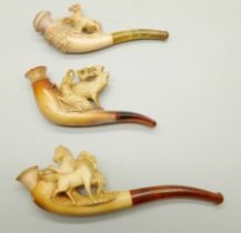 Three small hand carved Meerschaum pipes, two with horses and one with a pair of stags, amber stems,