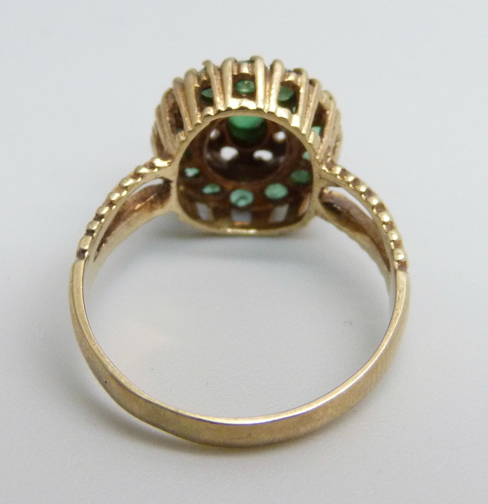 A 9ct gold ring, set with a green centre stone and surrounded by fourteen emeralds, 3.3g, O - Image 3 of 3