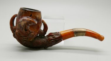 A carved Meerschaum pipe in the form of an eagle's claw with amber stem, cased