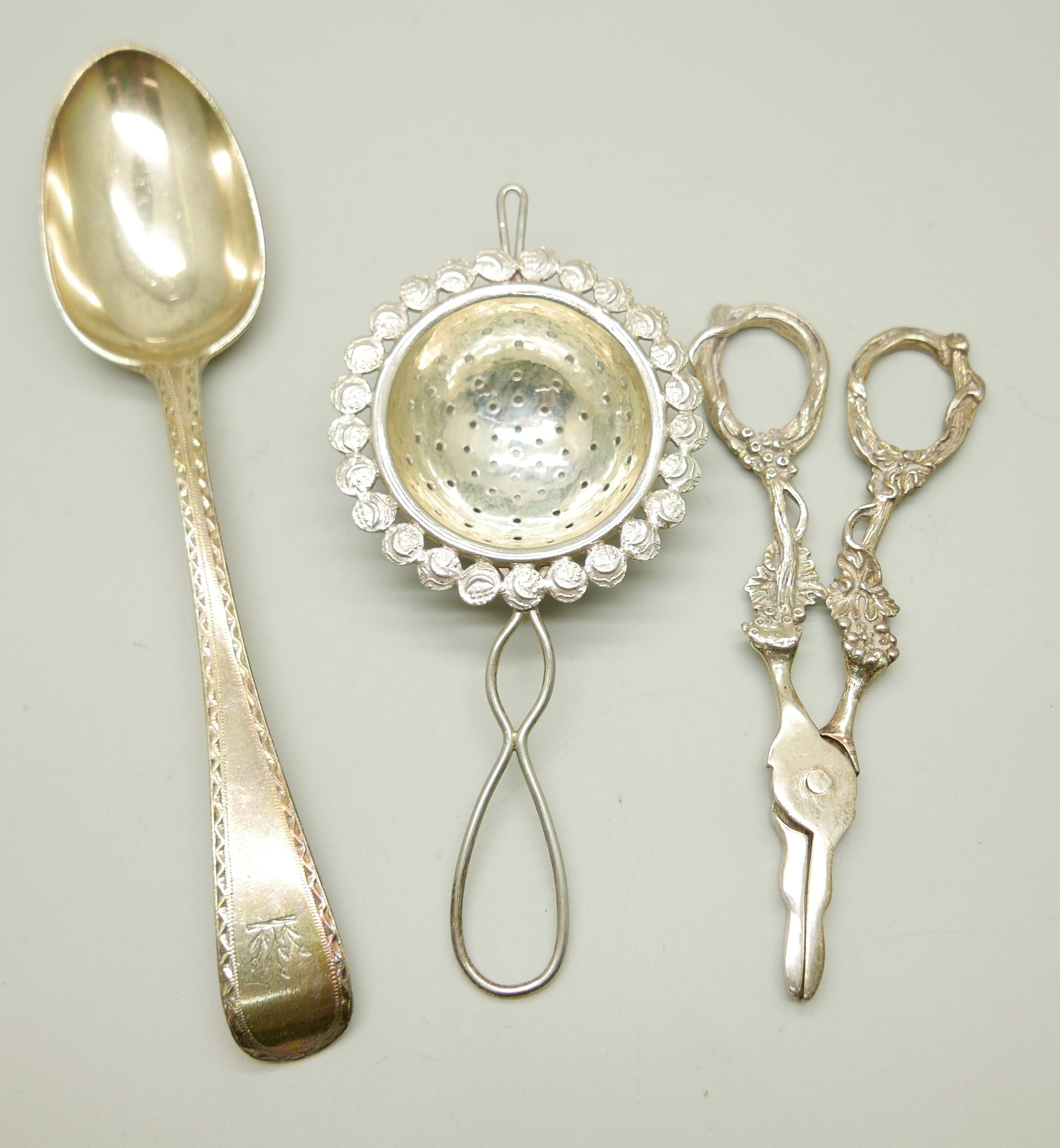 A Victorian silver spoon by George Adams, a strainer and a pair of silver grape scissors, (spoon and