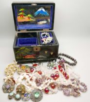 A Japanese style musical jewellery box with costume jewellery, vintage Hollywood brooch and a Sara