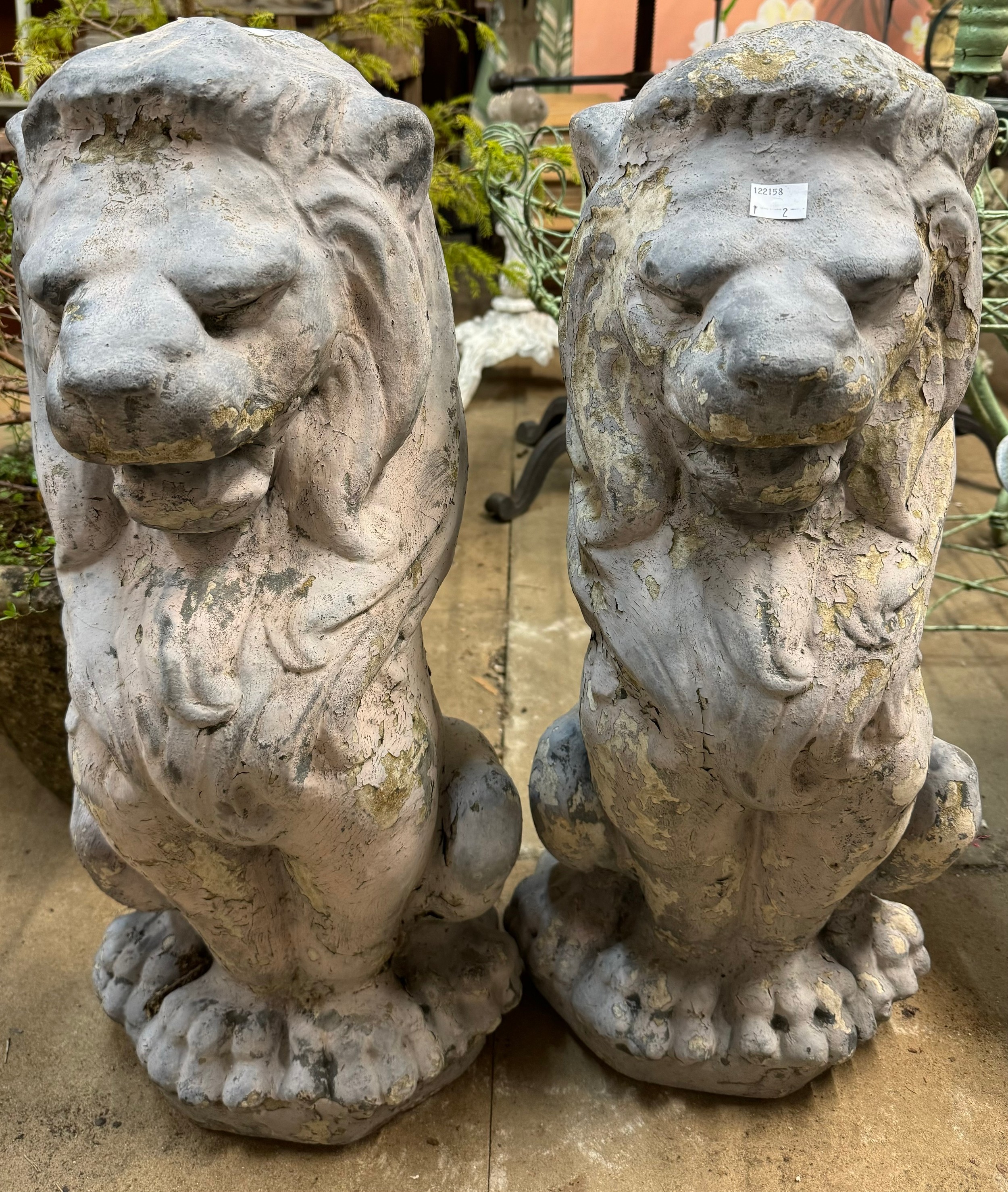 A pair of concrete garden figures of seated lions