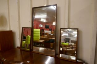A pair of teak framed mirrors and one other