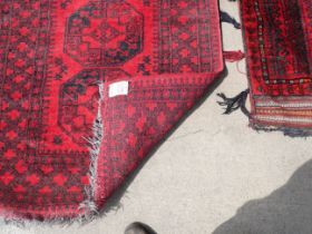 An eastern red ground rug and a Turkish salt bag