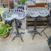 A pair of cast iron tractor seat stools