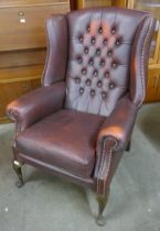 A burgundy leather Chesterfield wingback armchair
