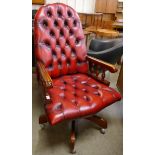 A beech and oxblood red leather revolving desk chair