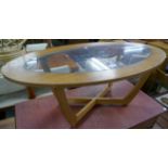 A teak and glass topped oval coffee table