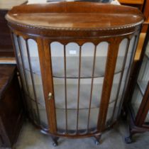 An early 20th Century oak demi lune display cabinet