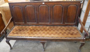 A George III panelled oak settle