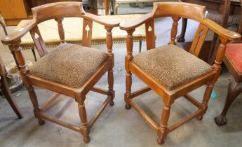 A pair of Arts and Crafts style oak corner chairs