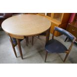 A Danish Frem Rojle teak and rosewood effect Roundette dining table and four chairs, designed by