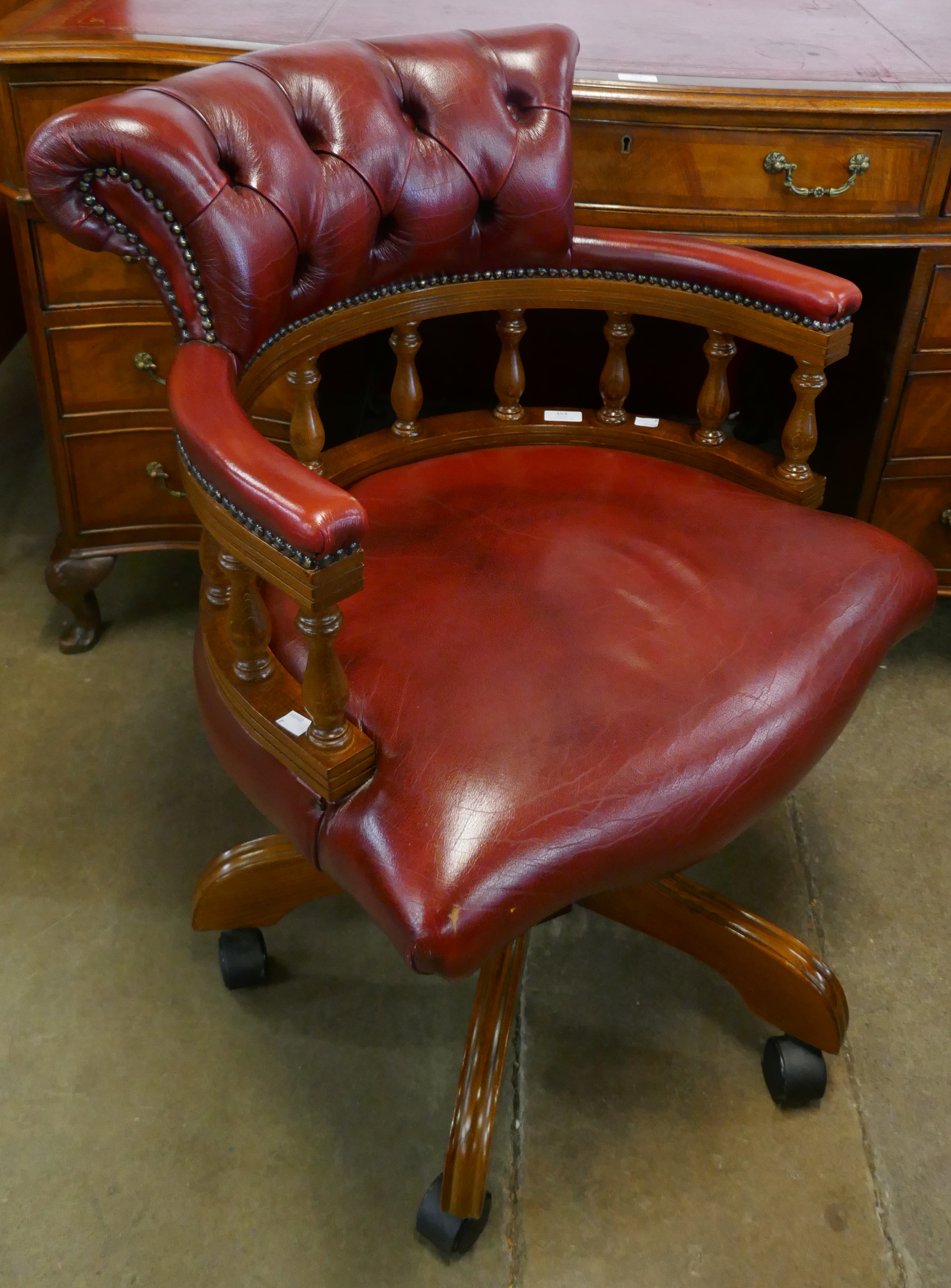 A mahogany and red leather revolving Captain's desk chair